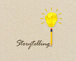 © Stockwerk-Fotodesign - Yellow lightbulb made of crumpeld paper with pencil writing the word storytelling