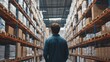 © MAGNIFIER - Employee examining the arrangement of goods on racks, large warehouse, back view