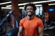 © Markus Schröder - Portrait of a glad afro-american man in his 30s wearing a moisture-wicking running shirt on dynamic fitness gym background