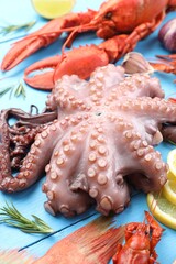 Wall Mural - Different sea food on light blue wooden table, closeup