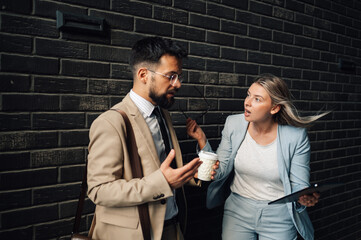 Businesswoman having heated discussion with male colleague outside office