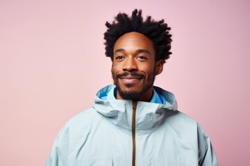 Poster - Portrait of a blissful afro-american man in his 30s wearing a functional windbreaker isolated in pastel or soft colors background