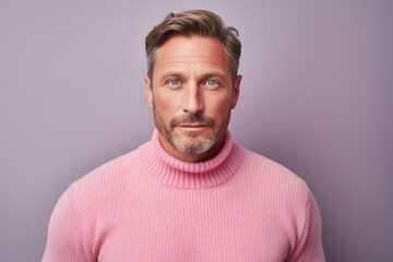 Poster - Portrait of a content man in his 40s dressed in a warm wool sweater in front of pastel or soft colors background