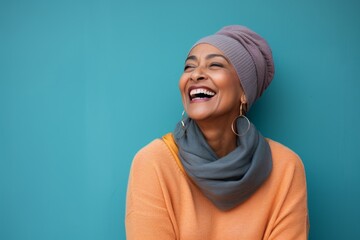 Poster - Portrait of a joyful indian woman in her 50s donning a warm wool beanie in front of pastel or soft colors background