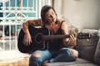 © Malambo/peopleimages.com - Woman, relax and guitar in home for music, practice and learning chords on sofa. Musician, string instrument and strumming in living room with talent, pitch development or rehearsal for performance