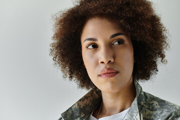 A strong young African American woman dressed in camouflage exudes determination and pride in her military role.