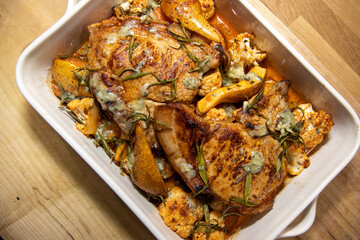 A delicious dish of Pork Pear sweet potato and stilton tray roast on a wooden kitchen table or work top