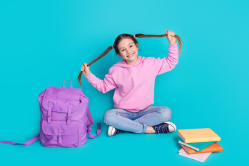 Wall Mural - Full size photo of pretty little girl pull tails sit floor school sales wear trendy pink outfit isolated on aquamarine color background