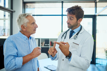 Canvas Print - Senior man, doctor and consulting with patient for medical dosage, prescription or side effects at clinic. Mature, male person and healthcare professional explaining for health advice or consultation