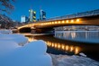 © Thanyarat - Frankfurtâ€™s bridges covered in snow, with soft lights reflecting off the icy river below