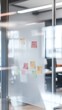 © Tadeusz - Colorful sticky notes on a glass board in a modern office setting.