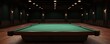 © Jammy - Empty billiard room with a green pool table on a polished wooden floor.