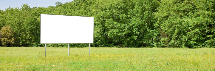 Empty advertising billboard in a rural landscape surrounded by t