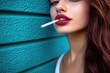 © Konstiantyn Zapylaie - Stylish woman with red lips leaning against turquoise wall smoking cigarette