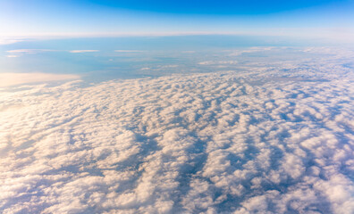 Beautiful orange and pink sunrise over the clouds, view from the plane.