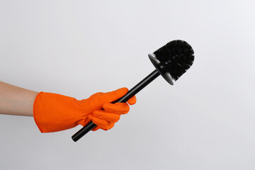 Canvas Print - Woman holding black toilet brush on light background, closeup. Cleaning tool