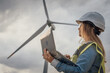 © YURIMA - A skilled female engineer monitors wind turbines on her laptop, crucial in developing sustainable energy solutions and advancing technology and infrastructure for a cleaner future