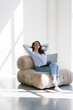 © F8  \ Suport Ukraine - Young woman relaxing with her hands behind her head and sitting on a chair