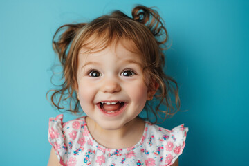 portrait of surprised smiling cute little toddler girl. child standing isolated over blue background