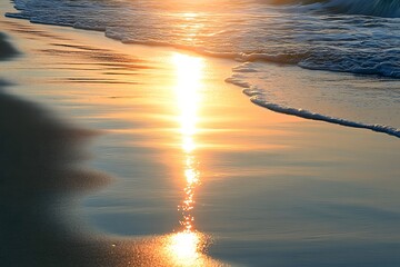 Wall Mural - The soft glow of the setting sun reflecting off wet sand as gentle waves wash ashore creating a peaceful scene