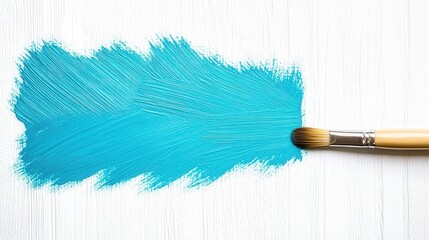 Paintbrush creating a bright blue stroke on white wood