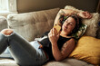 © Malambo/peopleimages.com - Home, relax and woman on sofa, smartphone and internet with social media, texting and communication. Headphones, person or girl on couch, cellphone or typing with message to contact or calm in lounge