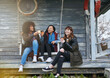 © SunriseDon/peopleimages.com - Portrait, people and women at outdoor cabin with smile, holiday adventure or bonding on lakehouse porch. Coffee, winter fun and girl friends cheers on cottage patio for happy travel vacation together