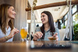 © Mediteraneo - Two girl best friends having out at the restaurant. Drinking coffee and orange juice. They gossip, laugh and have fun time.