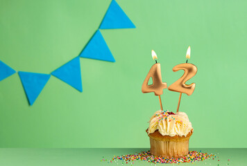 Canvas Print - Birthday card with number 42 candle - Cupcake on a green background with blue pennants.