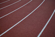 © catahula - Red rubber track and field lines, lanes background texture