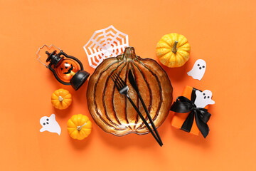 Poster - Festive table setting for Halloween celebration with gift box and decorations on orange background