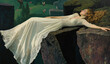 © SASI   SPACE - A bride wearing her beautiful floral white wedding dress laying posing on cliff edge, mountain in background for unique artsy wedding planning travel photography concept