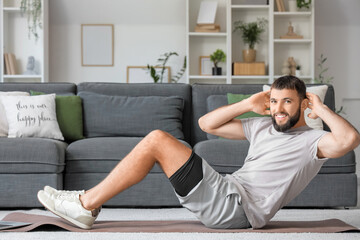 Sticker - Sporty young man exercising on yoga mat at home