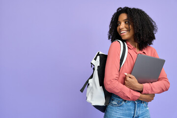 happy young african american girl holding laptop standing isolated on purple background, smiling fem