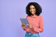 © insta_photos - Happy young African American girl student holding digital tablet standing isolated on purple background, smiling female professional model employee working on pad device. Portrait.