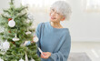 © siro46 - クリスマスツリーのオーナメントを飾るシニア女性
