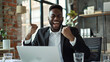 © CNISAK - Professional Man Celebrating Success While Working on a Laptop in a Modern Office