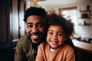 Smiling portrait of a young father and his daughter at home