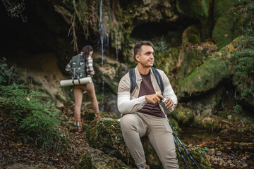 Adult man hiker backpacker have a rest and drink from metal bottle