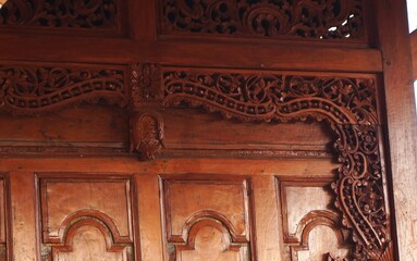 photo of a beautifully carved window made of wood looks old and classic