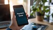 © slamet - Person Holding Smartphone Confirming Successful Payment in Modern Office Environment