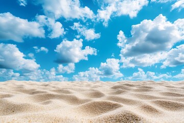 A panoramic view of a sandy beach under a bright blue sky with puffy white clouds.