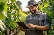 © The Little Hut - a happy young male farmer using a digital tablet while tending to crops in a garden : Generative AI