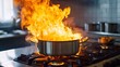 © ORG - A kitchen fire accident, with intense flames rising from a cooking pot on the stove, representing the dangers of unattended cooking
