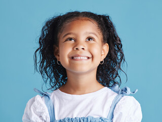 Girl, child and smile with thinking in studio of happy memory, curious imagination and daydreaming. Person, kid and thoughtful on blue background with wondering, remember and ideas on mockup space