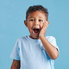 Shout, shocked and portrait of child in studio for information, announcement and danger expression. Scared, boy and face of little kid with emoji reaction for fear, terror or news by blue background