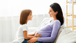 © Prostock-studio - Expecting mother having conversation with her little preschool daughter, spending time together at home