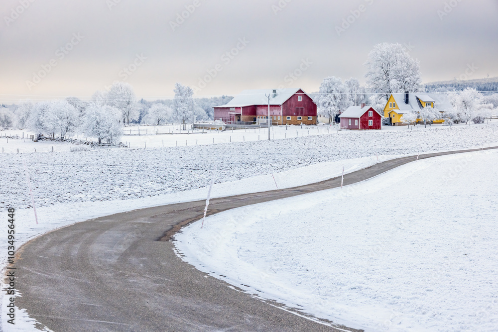 Snowy winding country road to a farm in the countryside in the winter ...