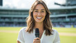 © romanets_v - Smiling female sports reporter holding microphone on cricket field at stadium