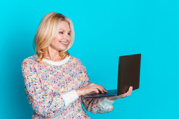 Wall Mural - Portrait of pretty aged lady use laptop wear sweater isolated on turquoise color background